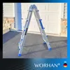 A silver and blue multi-purpose ladder is set up in an A-frame position on an asphalt driveway in front of a white garage door. Produktbild-Vorschau