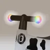Close-up of the handlebars of a children's ride-on toy, featuring glowing multicolor grips. Anteprima dell’immagine prodotto