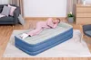 A woman sleeping on an inflatable mattress in a living room. Produktbild-Vorschau