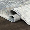 A close-up of a rolled-up rug on a dark wooden floor. Produktbild-Vorschau