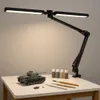 A black LED desk lamp is clamped to a white table, illuminating a model tank and painting supplies. Náhľad obrázku produktu
