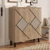 A wooden cabinet with a rattan pattern on the doors is shown in a hallway setting, next to a door and a bench with shoes underneath. Anteprima dell’immagine prodotto