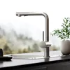 A modern kitchen faucet is shown in front of a blurred natural landscape. Produktbild-Vorschau