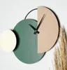 A modern, abstract wall clock with geometric shapes and black hands. Produktbild-Vorschau