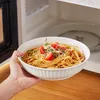 Eine gefüllte Schale wird vor die geöffnete Mikrowelle gehalten. Náhled obrázku produktu