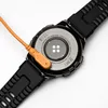 The back of a smartwatch is shown with its charging cable attached. Produktbild-Vorschau