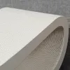 A close-up view of a white scratching board for cats, showing its textured surface and layered cardboard construction. Produktbild-Vorschau