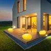 A modern house with a wooden deck and garden at dusk, illuminated by yellow LED stone lights. Produktbild-Vorschau