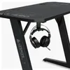 A close-up view of a black gaming desk with a pair of headphones hanging from a hook underneath the tabletop. Produktbild-Vorschau