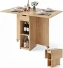 A wooden dining table with drop-leaf extensions, storage compartments, and wheels, set up with place settings. Náhľad obrázku produktu