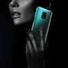 A person's hand is holding a transparent phone case with a green smartphone inside, against a black background. Anteprima dell’immagine prodotto