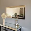 A decorative mirror and console table set up in a room. Produktbild-Vorschau