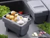 A kitchen counter with two storage containers for vegetables, one filled with onions and garlic, and another closed container. Anteprima dell’immagine prodotto