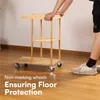 A person's hands are resting on a wooden cart with shelves, which has wheels. Anteprima dell’immagine prodotto