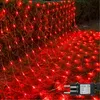 A net of red lights is draped over grass and bushes, with a power adapter visible. Produktbild-Vorschau