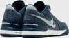 A close-up rear view of a pair of blue Nike sneakers. Náhľad obrázku produktu