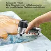 A hand holding a portable vacuum cleaner, using it to remove air from a vacuum storage bag containing bedding. Produktbild-Vorschau