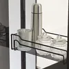 A close-up view of a wire basket holding kitchen or pantry items, including a thermos, a glass, and two glass jars with lids, on a shelf. Produktbild-Vorschau