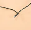 A close-up shot of a single LED light on a black wire, set against a plain light peach background. Produktbild-Vorschau