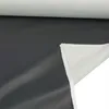 A roll of dark grey faux leather fabric with a white backing is shown, with the fabric unrolled to reveal both sides. Podgląd zdjęcia produktu