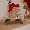 A baby is playing with a wooden activity table in a festive setting with Christmas decorations. Podgląd zdjęcia produktu