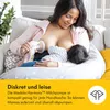 A woman is breastfeeding a baby while using a breast pump. Podgląd zdjęcia produktu