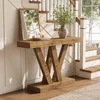 A wooden console table with a mirror and vase of flowers in a hallway with stairs. Podgląd zdjęcia produktu