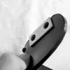 A finger is pressing on a black object with silver accents. Anteprima dell’immagine prodotto