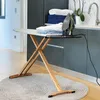 An ironing board with an iron and folded clothes in a laundry room setting. Produktbild-Vorschau