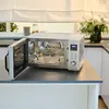 A silver microwave oven with its door open, placed on a kitchen counter. Produktbild-Vorschau