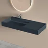 A dark gray wall-mounted sink with a chrome faucet is shown against a light beige wall. Produktbild-Vorschau