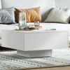 A white coffee table with decorative items on it, placed in a living room setting with a sofa and rug. Voir les images du produit