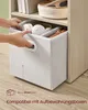 Hands placing a storage box into a shelf of a bookshelf. Produktbild-Vorschau