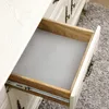 An open drawer in a white dresser, lined with a gray textured mat. Náhled obrázku produktu