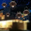 Several solar-powered lanterns hang from tree branches at dusk, with a blurred house in the background. Produktbild-Vorschau