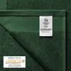 A close-up view of a dark green towel, showing the texture and care labels. Produktbild-Vorschau