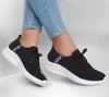 A pair of black Skechers Ultra Flex 3.0 - Brilliant women's sneakers with white soles, worn by a person in light blue jeans. Produktbild-Vorschau