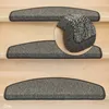 Several grey stair mats are placed on wooden stairs. A close-up of one of the stair mats is shown in a circular inset. Produktbild-Vorschau