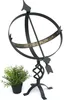 A black metal sundial on a stand, with a small potted plant to the left. Anteprima dell’immagine prodotto