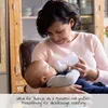 A woman is feeding a baby with a bottle. Produktbild-Vorschau