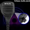 A close-up of a black microphone with a 3.5mm audio jack, set against a dark background with glowing purple and blue concentric circles. Produktbild-Vorschau