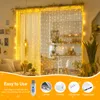 A living room with string lights decorating the curtains and a kitchen visible through them. Produktbild-Vorschau