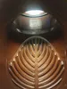 A close-up view inside a metallic and brown object, possibly a filter or strainer. Náhľad obrázku produktu