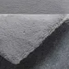 A close-up view of a gray, high-pile rug, showing its texture and backing. Produktbild-Vorschau