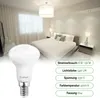 A bedroom scene with a bed and bedside tables, with a light bulb in the foreground and product specifications overlaid. Produktbild-Vorschau