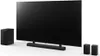 A black LG soundbar system with a subwoofer and two wireless speakers is displayed on a white background. Voir les images du produit