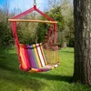 A colorful hammock chair hanging from a tree in a grassy yard. Náhled obrázku produktu