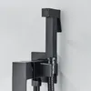 A close-up shot of a black bidet sprayer and its wall mount, attached to a white wall. Náhľad obrázku produktu