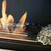 A close-up view of a bioethanol fireplace with flames and glass pebbles. Podgląd zdjęcia produktu