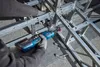 A person is using a power tool to assemble a metal structure. Produktbild-Vorschau